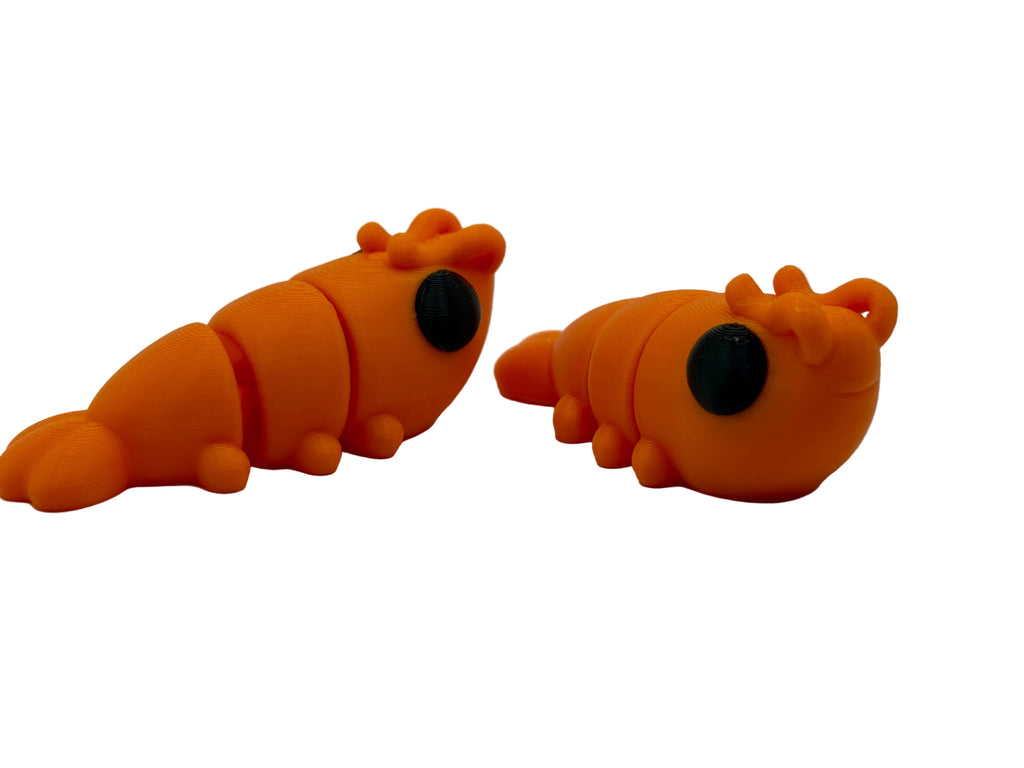 Two orange shrimp toys on a white background