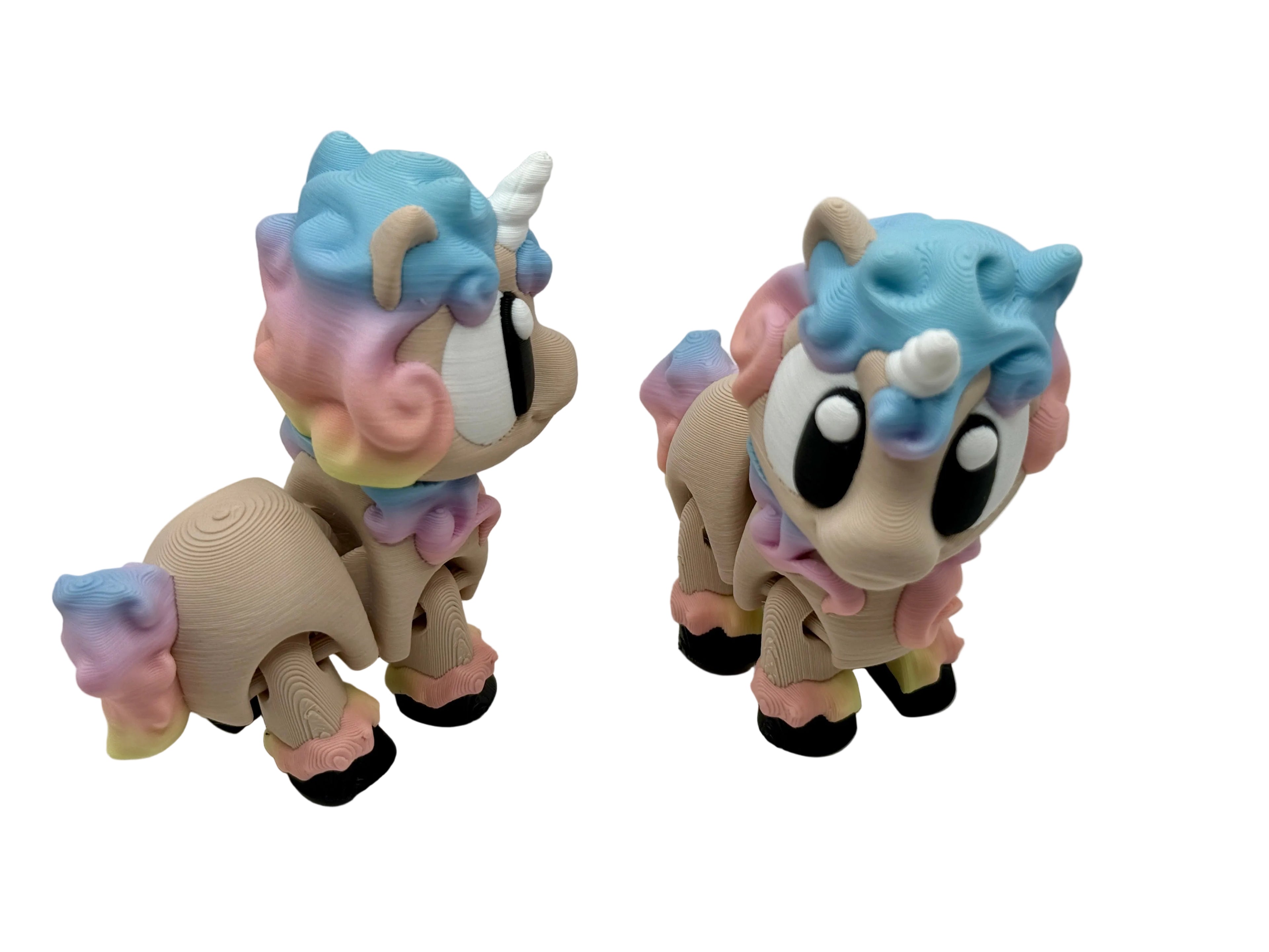 Two colorful unicorn figurines with pastel hair on a white background